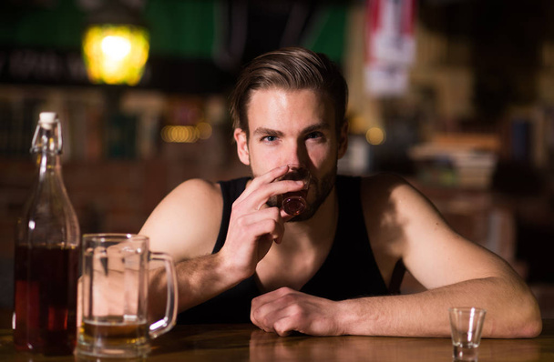 A regular alcohol drinking. Alcohol addict with short alcohol drink. Alcoholic man drinking at bar counter. Man drink strong alcoholic beverage and beer in pub. Alcohol addiction. Drinking alcohol - Foto, afbeelding