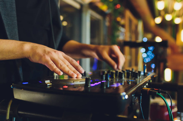 DJ playing music at mixer closeup and mixes the track in the nightclub at party. - 写真・画像