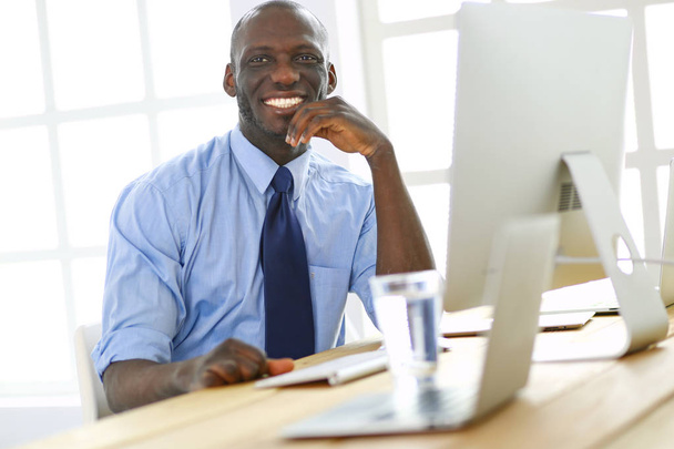 Afrikaans Amerikaans zakenman op headset werken op zijn laptop - Foto, afbeelding