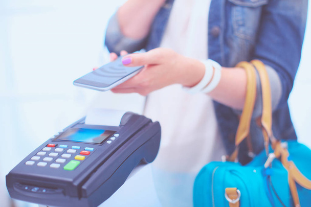 Πελάτης πληρώνει με το smartphone στο κατάστημα χρησιμοποιώντας τεχνολογία Nfc. Τεχνολογία NFC. Πελάτης πληρώνει - Φωτογραφία, εικόνα