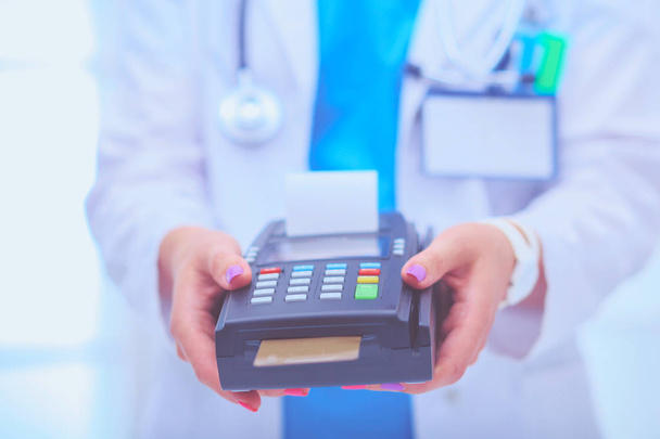 Doctor is holding payment terminal in hands. Paying for health care. Doctor - Foto, Imagem