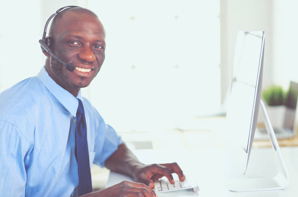 African american businessman on headset working on his laptop - Foto, immagini
