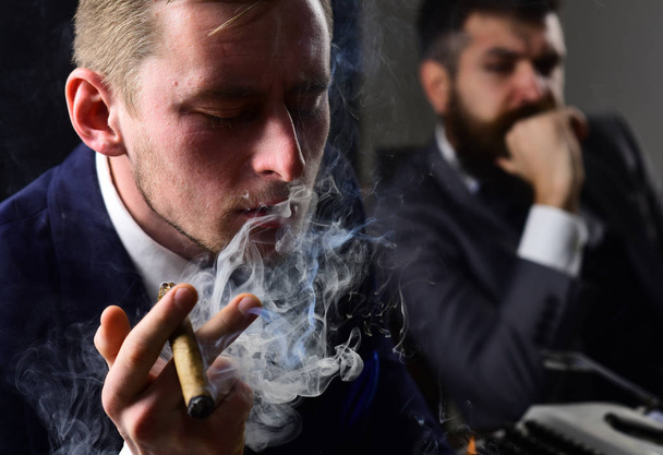 Thinking about problem solution. Thoughtful man smoking cigar. Businessmen hold business meeting. Business partners thinking together in office. Coworkers solving a business problem - Foto, Bild