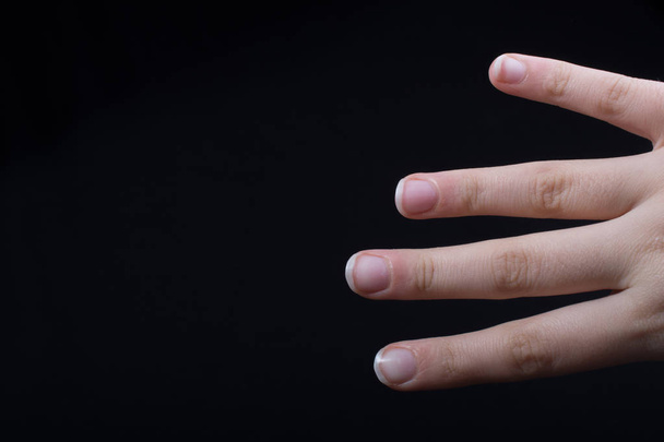 Чотири пальці руки дитини частково видно на чорному тлі
 - Фото, зображення