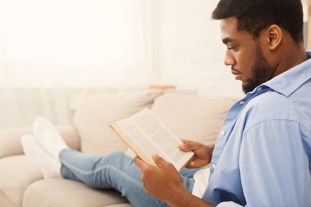 Estudiante negro leyendo libro en casa
 - Foto, imagen