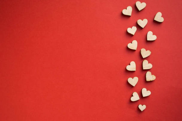 Red background with wooden hearts, place for text. The concept of Valentines Day. - Foto, Bild