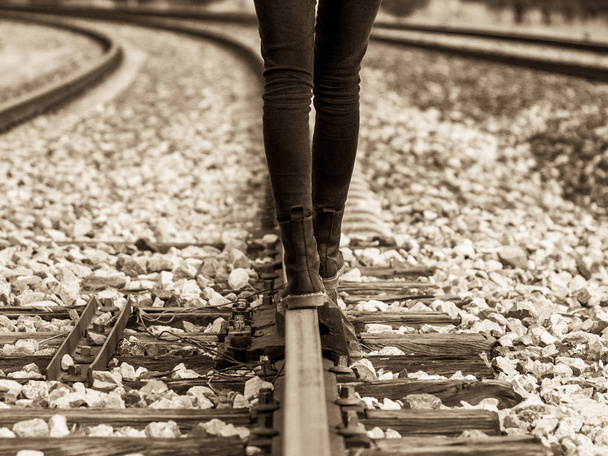 Sonbaharda tren raylarında yürüyen bir kadın. - Fotoğraf, Görsel