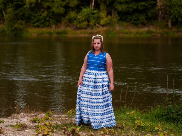 ブルーのパーティー ドレスを着て川で陽気な若い女性の肖像画 - 写真・画像