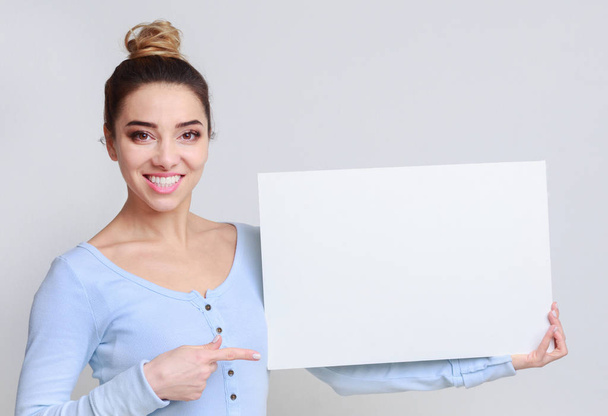 Счастливая женщина с доской для копирования для рекламы
 - Фото, изображение