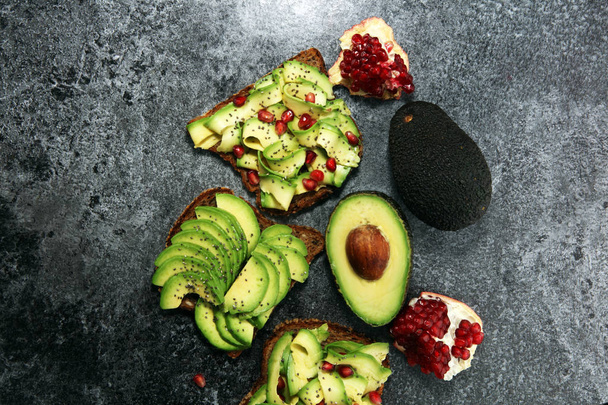 avocado affettato e melograni maturi su pane tostato con spezie e avocado
  - Foto, immagini