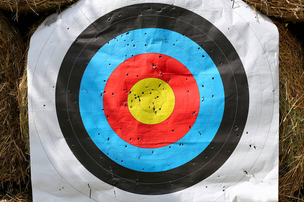 Красочный целевой шаблон для соревнований по спортивной стрельбе. Используемая цель с цветовыми кругами на стрельбище против тюков сена
 - Фото, изображение