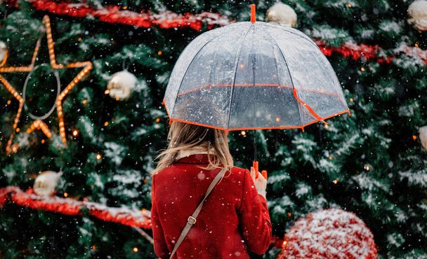 κορίτσι με ομπρέλα κοντά στο χριστουγεννιάτικο δέντρο - Φωτογραφία, εικόνα