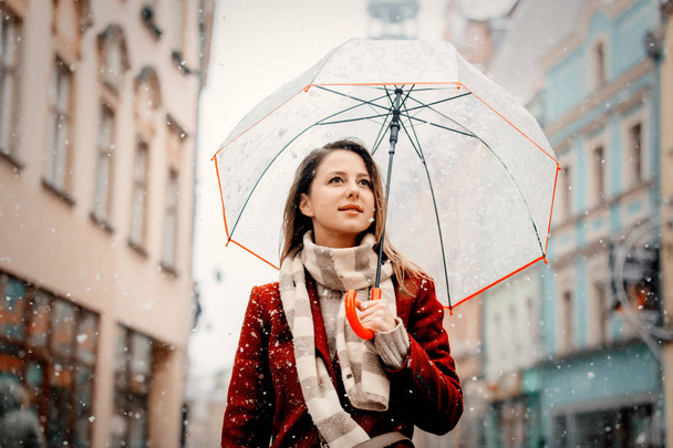 Девушка с зонтиком белый снег падает остаться на улице города
 - Фото, изображение