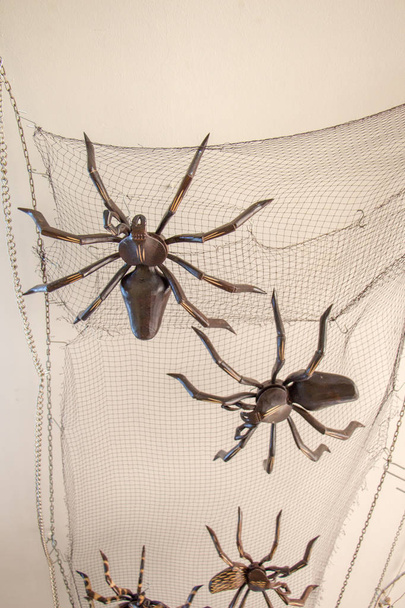 Figuras de aranha de aço em uma rede preta em exibição - Foto, Imagem