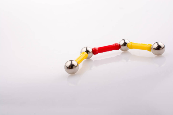 Магнітні іграшкові смужки та магнітні кульки на білому тлі
 - Фото, зображення