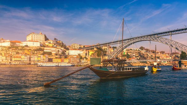 Port wine boats at the waterfront with Dom Luis bridge and the old town on the Douro River in Ribeira in the city centre of Porto in Porugal in Europe. Portugal, Porto - Photo, Image