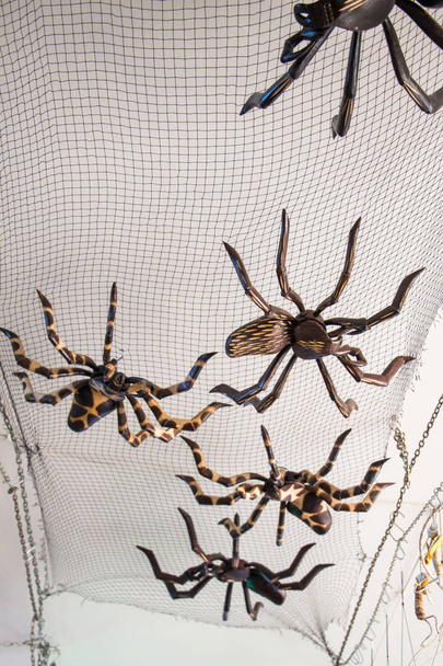 Figuras de araña de acero sobre una red negra en exhibición - Foto, Imagen