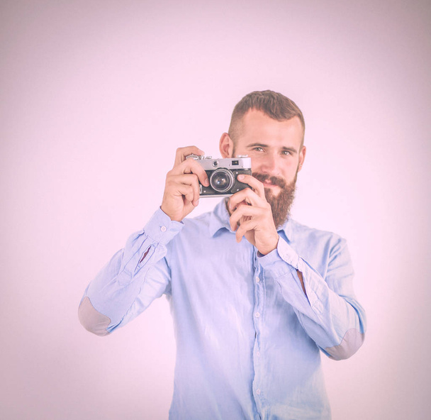 Portrait of a young photographer with a camera, isolated on white background - Foto, Imagen