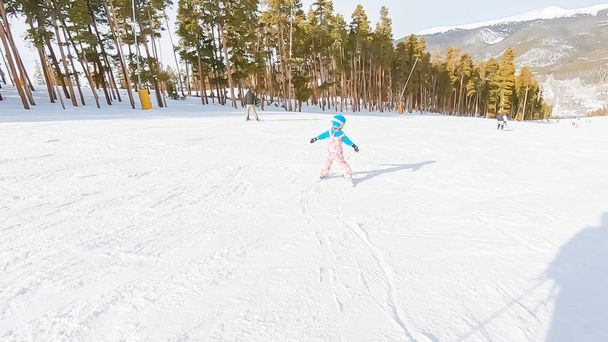 Meisje leren skiën naar beneden de heuvel op alpine bergen. - Foto, afbeelding
