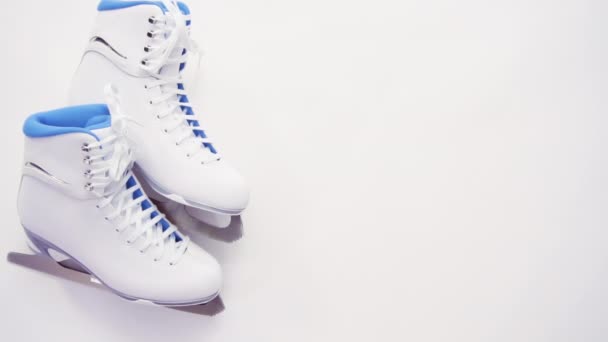 Acostado. Nueva figura blanca patina con protectores de patines azules sobre fondo blanco
. - Metraje, vídeo