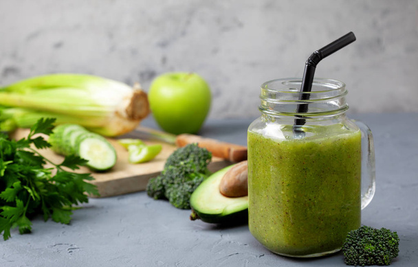green smoothies in glass jar mason with fresh vegetables and herbs: broccoli, avocado, lime, celery, apple, kiwi, parsley. detox smoothies - Fotó, kép