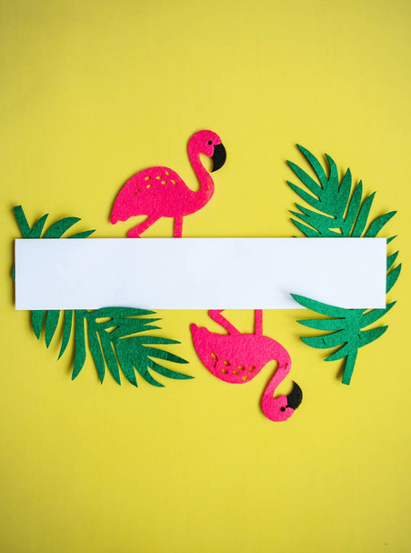 Summer design. Flamingo with tropical leaves on a yellow background. In the middle is a space for text - 写真・画像