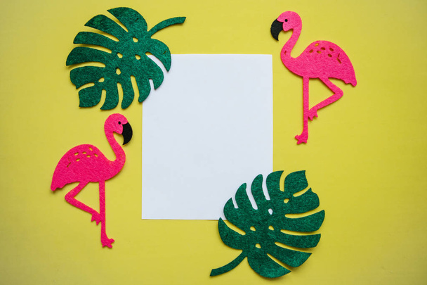 Zomer ontwerp. Flamingo met tropische bladeren op een gele achtergrond. In het midden staat een ruimte voor tekst - Foto, afbeelding