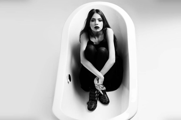 woman in dress with long hair, black lipstick in bath - Photo, image