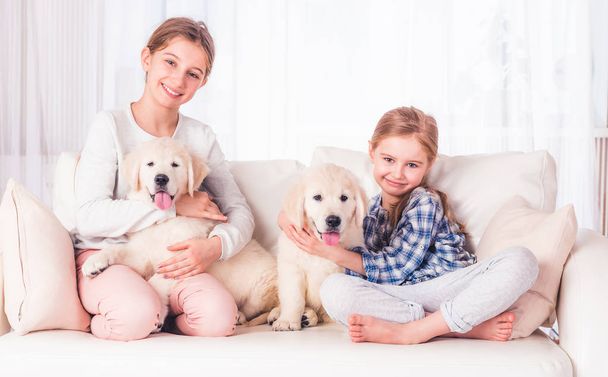Smiling sisters sitting with puppies - Φωτογραφία, εικόνα