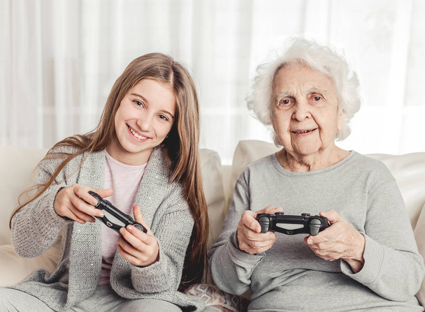 Grandmother with granddaughter playing games - Fotoğraf, Görsel