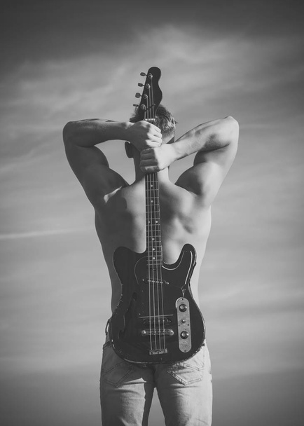 Sportsman with muscular back hold electric guitar - Foto, Imagem