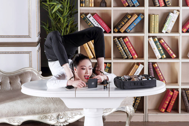 A contorcionista chinesa Liu Teng mostra a flexibilidade de seu corpo em sua nova sala de estar em casa em Pequim, China, 7 de agosto de 2016
 - Foto, Imagem
