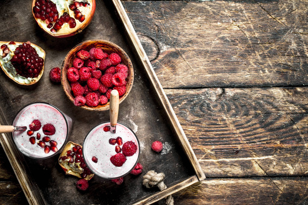 Pomegranate and fresh raspberry smoothie. On a wooden table. - Foto, imagen