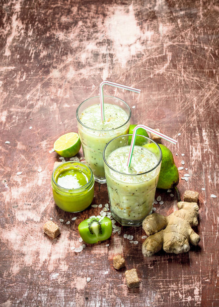Smoothie with pear, kiwi and ginger. On rustic background. - Photo, Image