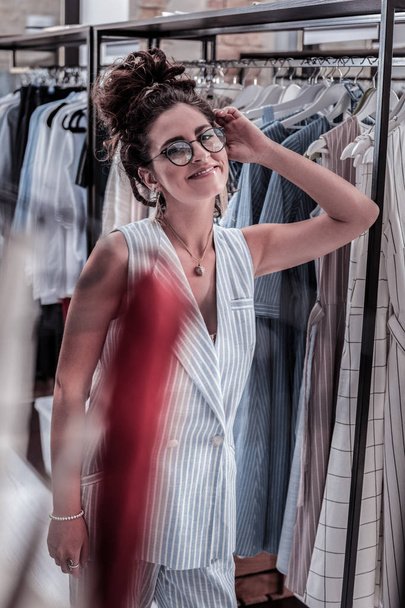Beaming happy woman wearing blue striped costume shopping in favorite boutique - Foto, Imagem