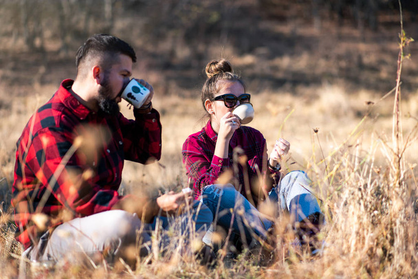 Pareja tomando una taza de café en el picnic al aire libre
 - Foto, Imagen