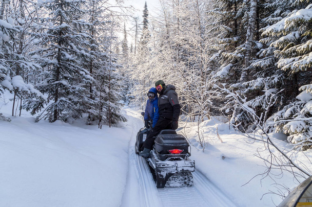 Athletes on a snowmobile moving in the winter forest in the mountains of the Southern Urals. - Photo, Image