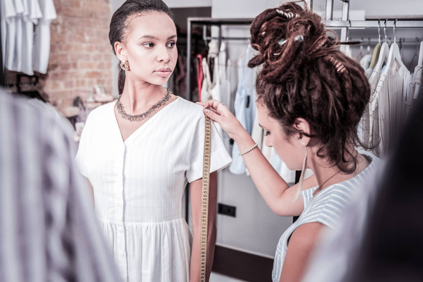 Beautiful dark-haired model standing near fashion designer measuring her body - Φωτογραφία, εικόνα
