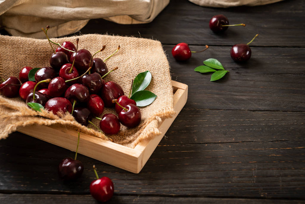 Fresh cherries in bowl  on wood background - Photo, image