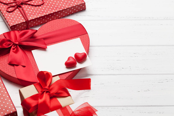Tarjeta de felicitación del día de San Valentín con cajas de regalo de corazón sobre fondo de madera
 - Foto, Imagen