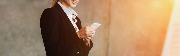 Cropped view of smiling businesswoman using smartphone in office - Фото, зображення