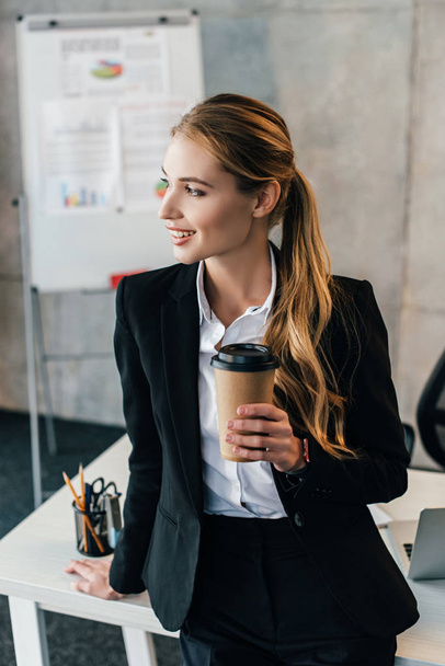 foyer sélectif de souriante femme d'affaires séjournant au bureau avec tasse d'élimination de café
 - Photo, image