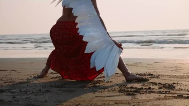 Gün batımında dans melek kanatları olan genç kızın ayak  - Video, Çekim
