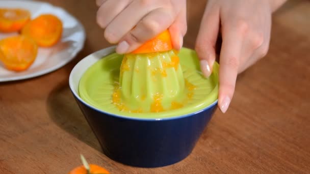 Női kéz nyomja össze a levet ki mandarin. - Felvétel, videó