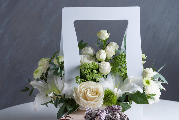roses blanches dans une boîte en papier blanc sur table et fond gris
 - Photo, image