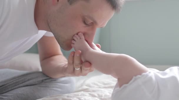 Close up shot of father kissing feet of baby - Záběry, video