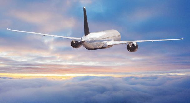 劇的な雲の上を飛ぶ民間航空機のジェット旅客機. - 写真・画像