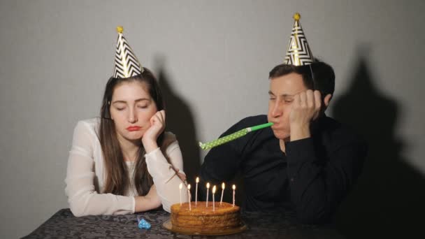 Triste mujer solitaria y hombre en sombrero de fiesta celebrando cumpleaños solo
 - Metraje, vídeo