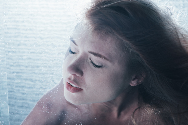 primer plano de la joven posando bajo el agua con los ojos cerrados
 - Foto, imagen