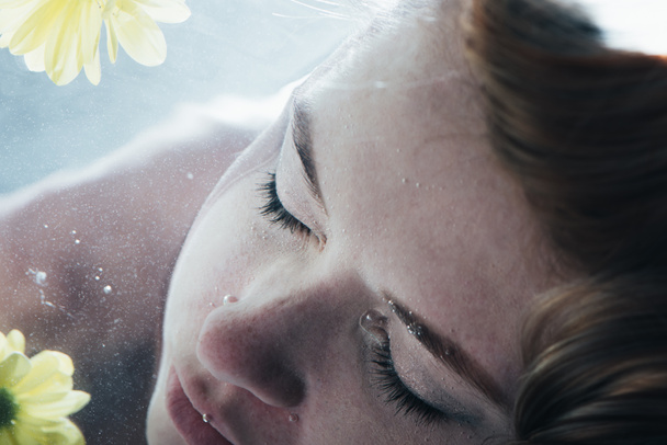 a gyönyörű lány pózol víz alatti csukott szemmel közelről - Fotó, kép